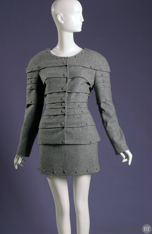 Soft long sleeve gray armor suit with horzontal tucks and decorative buttons with matching skir…