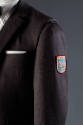 Detail of grey wool jacket shoulder and sleeve with arm patch and pocket square 