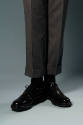 Detail of grey wool cuffed pants and black shoes