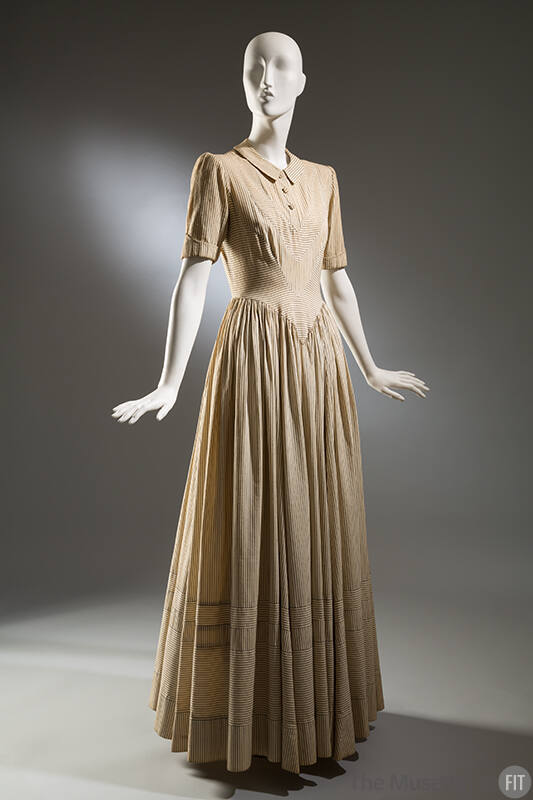 Cream full-length dress with corded pinstripes alternating with navy blue; fitted torso and ful…