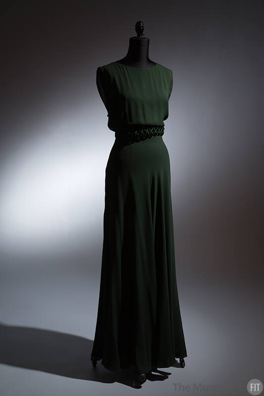 Dark green sleeveless floor length dress with lattice design piping at waist