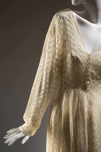 White sheer eyelet cotton gown with V-neck, long sleeves, and ten button & loop closings at bod…