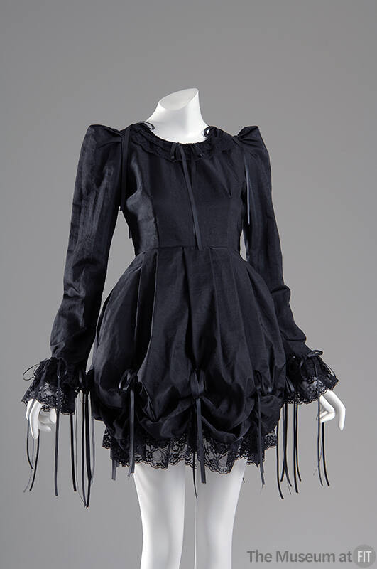 Black long sleeve mini dress with draped poof skirt and bows with long draping ends and lace tr…