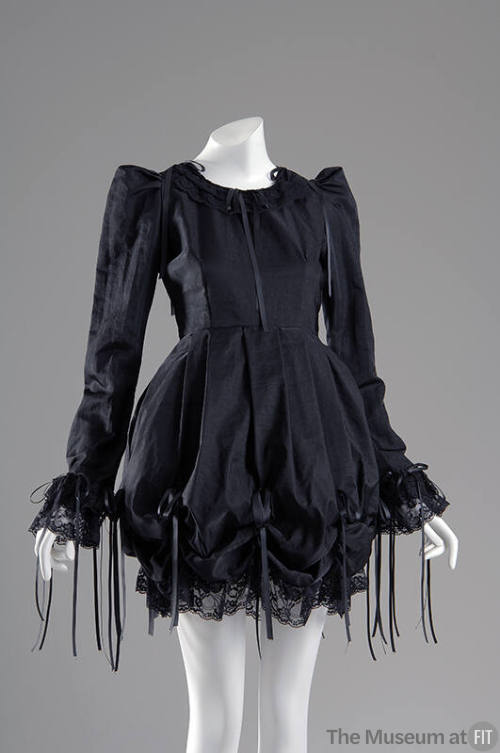 Black long sleeve mini dress with draped poof skirt and bows with long draping ends and lace tr…