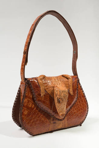 Brown alligator skin handbag with alligator head and paws at flap closure, shoulder strap