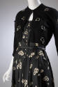 Black dress with cream floral print and button front bodice with black bolero embellished with …