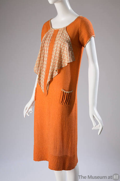 Orange short sleeve dress with triangular cascade of patterned orange and tan fabric from neckl…