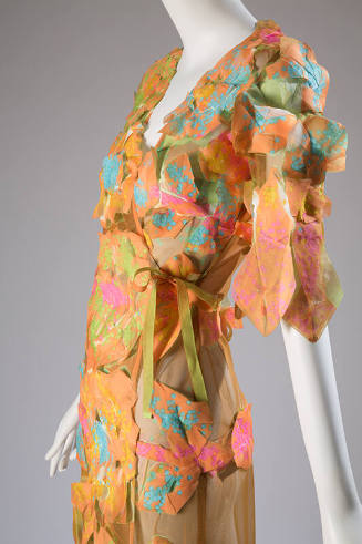 Detail of orange, pink and green sheer pieced rosette dress with side ribbon tie