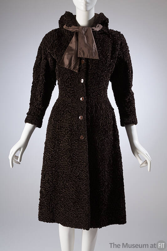 Brown, knee length hooded coat with wide, lightly padded shoulders and self tie bow at collar