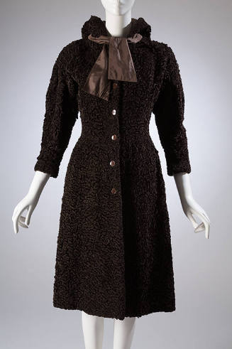 Brown, knee length hooded coat with wide, lightly padded shoulders and self tie bow at collar
