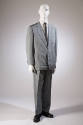 Man’s grey suit of notched lapel jacket with three patch pockets and matching pants dressed wit…
