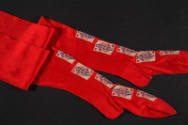 Pair of red stockings with playing cards embroidered down front