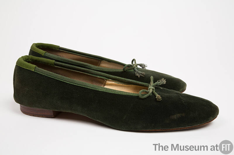 Pair of dark green velvet ballet flats shown side by side with green grosgain binding and tie a…
