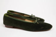 Pair of dark green velvet ballet flats shown side by side with green grosgain binding and tie a…