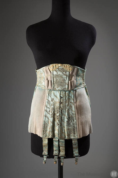 Blue/green girdle with gold brocade floral and ribbon motifs, elastic panels on either side and…