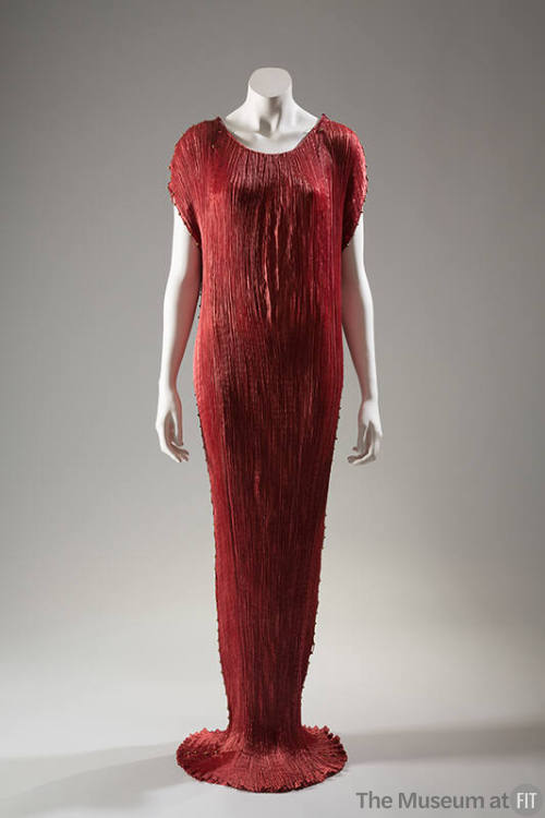 Red pleated silk teagown trimmed with yellow beads, floor length that slightly pools, sleeveles…