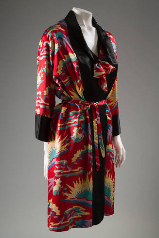 Red robe wirh yellow, purple and green sunburst design, bow and belt, black trim and cuffs