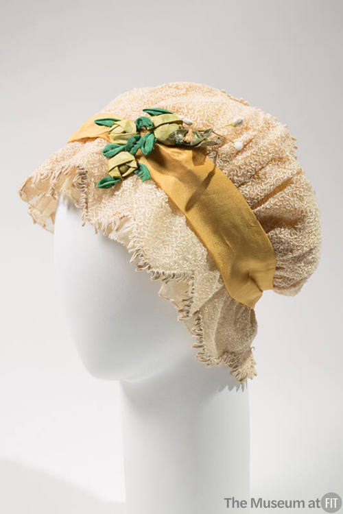 White net night cap with embroidery, yellow ribbon, and green flowers