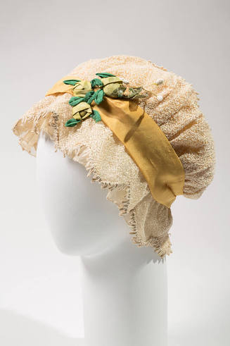 White net night cap with embroidery, yellow ribbon, and green flowers