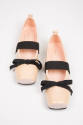 Pale pink square toe ballet flats with black bow and wide instep strap extended to sole