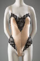 Peach teddy with wide black lace bands at v-shaped neckline and high cut leg side panels