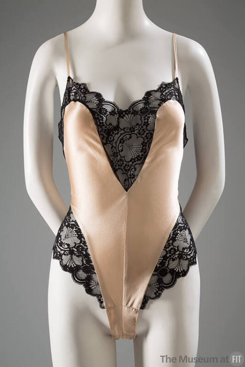Peach teddy with wide black lace bands at v-shaped neckline and high cut leg side panels