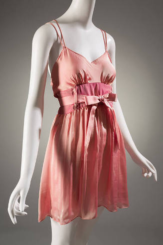 Pink baby doll style slip with tie belt at waist and spaghetti straps