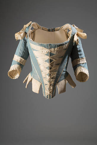 Blue stays with elbow length sleeves and white ribbon trim on shoulders, sleeves and criss-cros…