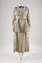 White and vertical black striped suit with below hip length two-button jacket, matching belt an…