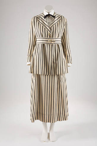 White and vertical black striped suit with below hip length two-button jacket, matching belt an…