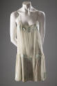 Pale green camiknickers with green satin spaghetti straps and rectangular insets at bust, along…
