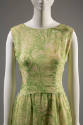 Detail view of front bodice of green and white sleevless sheath dress with leaf print and high …