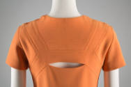 Back detail of short sleeved orange dress with horizonal slit
