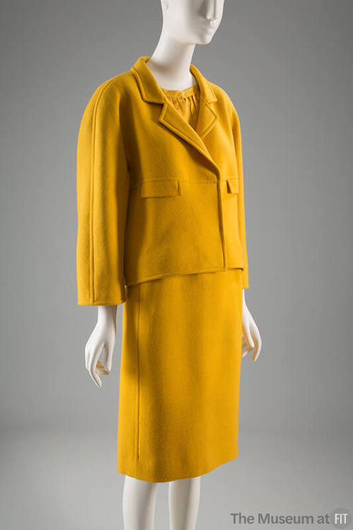 Yellow suit with small notched lapels and knee length straight skirt