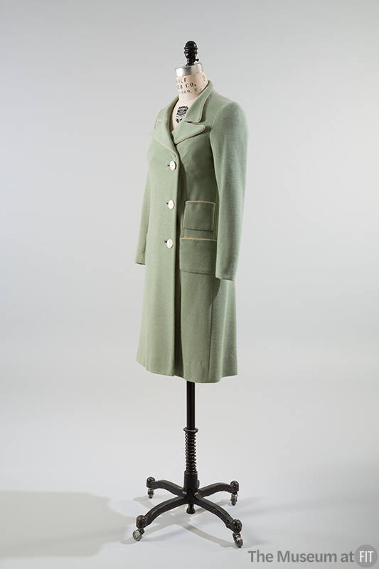Pale green coat with three button closure and two patch pockets on right hip
