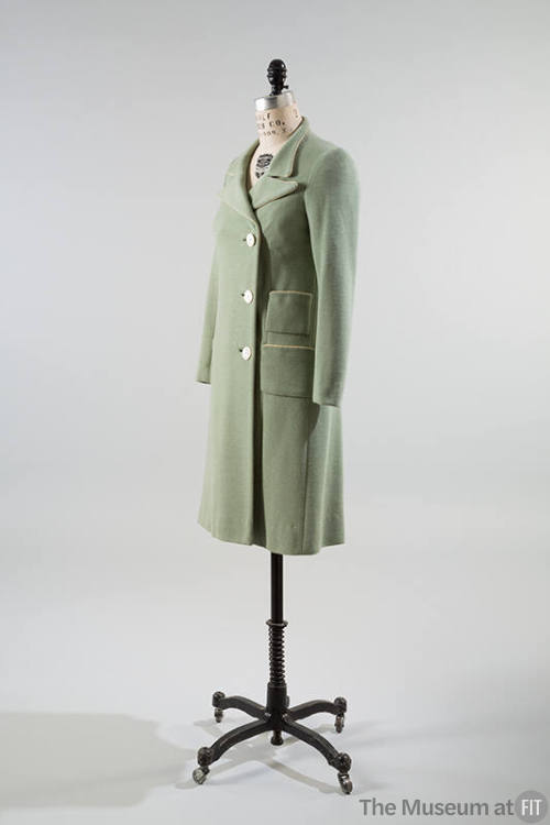 Pale green coat with three button closure and two patch pockets on right hip
