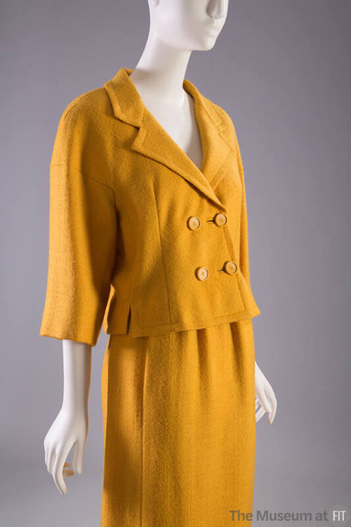 Gold double breasted suit with ¾ length sleeves and matching knee length skirt