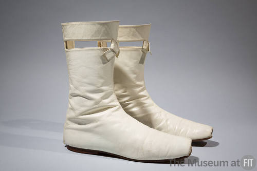 Pair of off-white leather boots with open toes and cut-out slits at tops