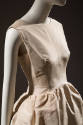 Sleeveless ivory dress, fitted bodice and skirt gathered at drop waist