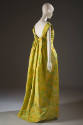 Back view of long evening dress with abstract floral chiné print in shades of green, yellow and…