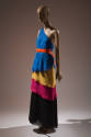 Blue, yellow, pink, black layered one shoulder floor length dress with orange belt