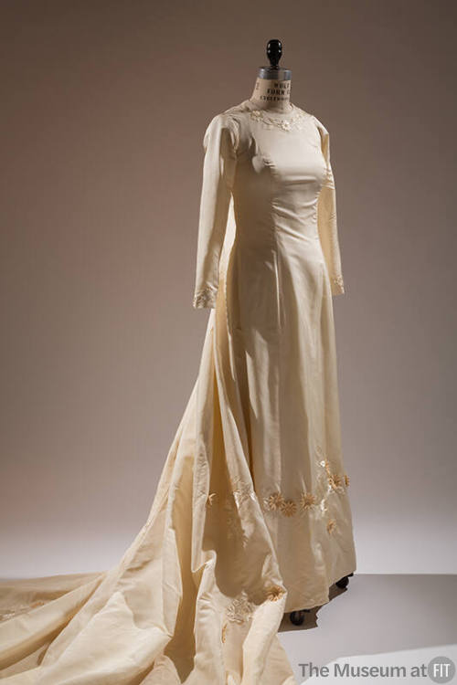 Off-white wedding gown with long sleeves and embroidered and appliqued flowers at round necklin…