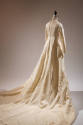 Back view of off-white wedding gown showing center back button and loop closure and long skirt …