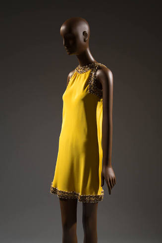 Bright yellow sleeveless evening mini dress with beaded trim at neckline, armholes, and hem wit…