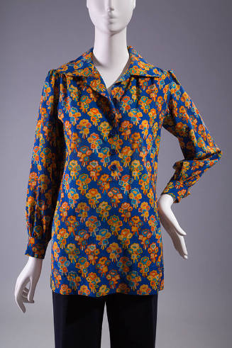 Royal blue long sleeve tunic top with blue, orange, yellow and off-white floral print, spread c…