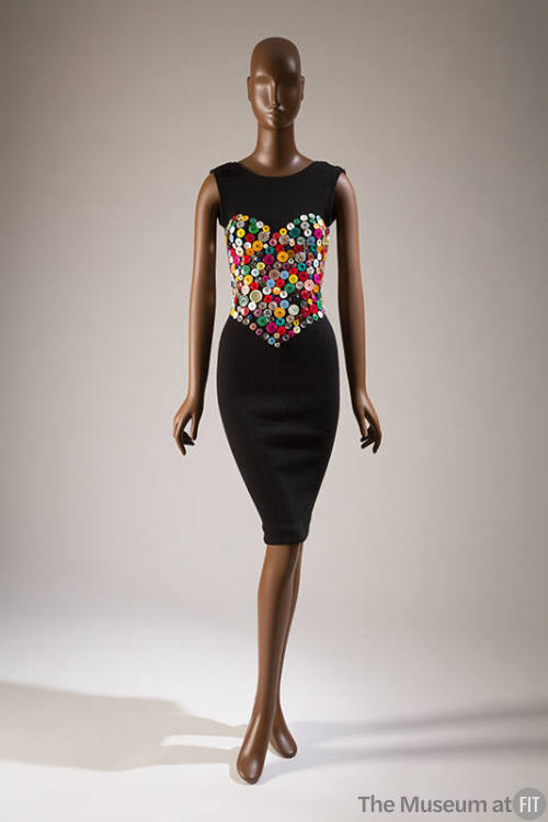 Black fitted sleeveless knee length dress with heart shaped bustier design made of various butt…