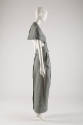 Side view of teal and white suit showing open lower half of jacket and floor length panel on si…