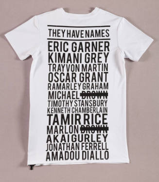 White short sleeve t-shirt covered in black writing reading “They have names” and 13 names with…