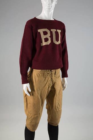 Man’s dark red sweater with white “BU” on center chest dressed with tan knee length football kn…