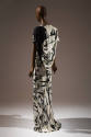 Back view of off-white floor length dress printed with gray stones with black shadows and yello…